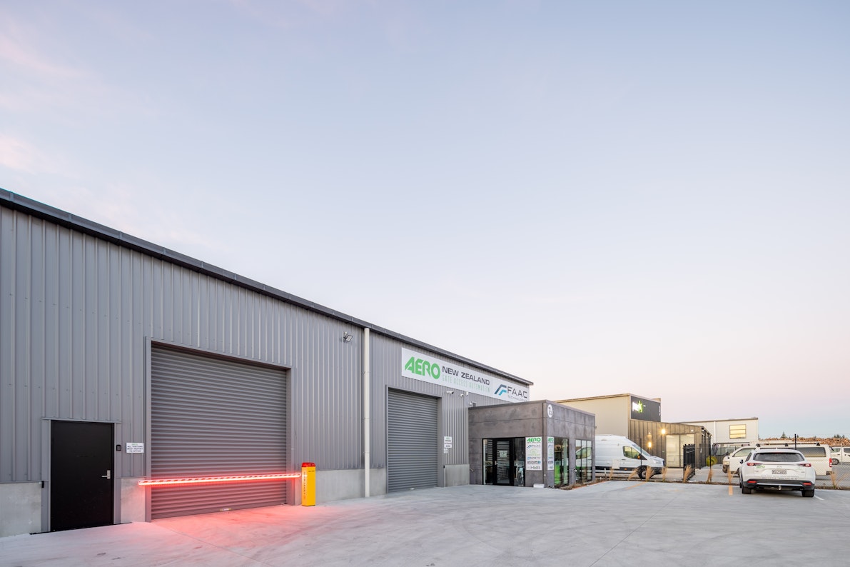A multi-tenancy warehouse features oversized roller doors with secure access and an attached office on the front